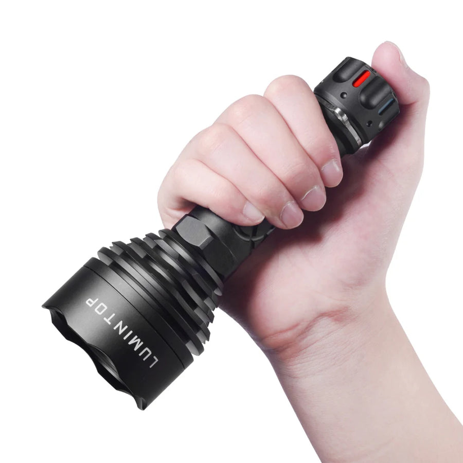 Hand holding a black flashlight with 'LUMINTOP' branding on a white background