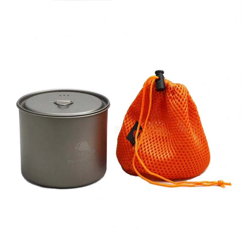 Gray camping pot with a lid and an orange mesh storage bag on a white background