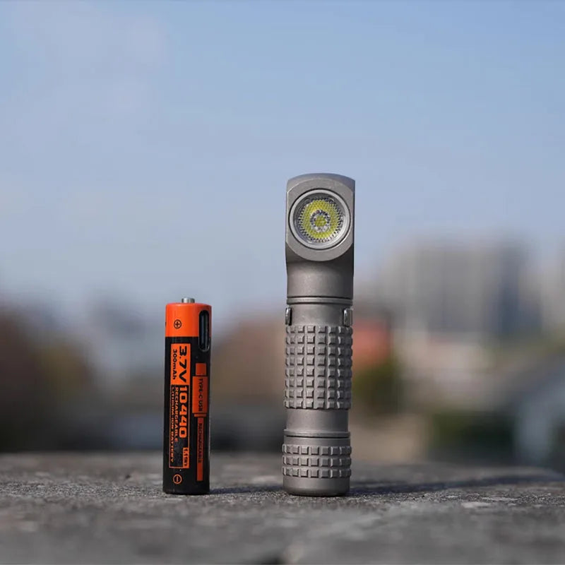 Flashlight and battery on a blurred natural background
