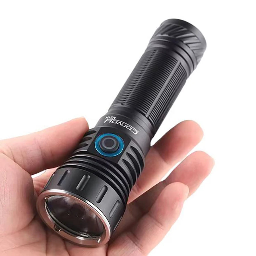 Black flashlight held in a hand against a white background