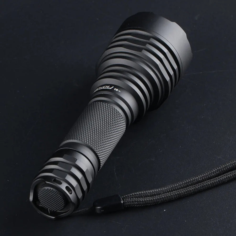 Black flashlight with textured grip and visible brand logo on a dark background