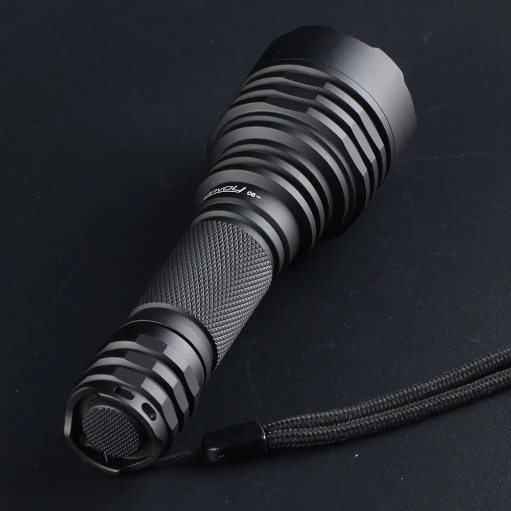Black flashlight with textured grip and visible brand logo on a dark background