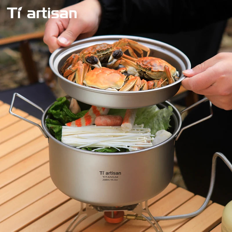 Cooking setup with crabs and vegetables on a portable stove, featuring Tiartisan branding.