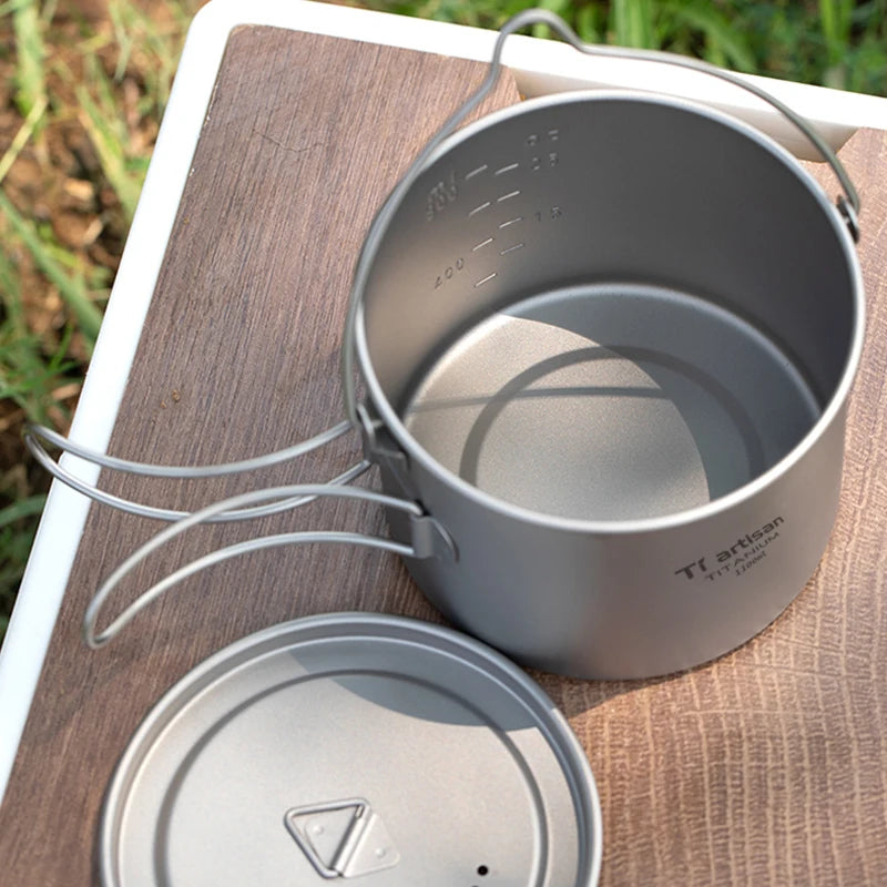 Gray camping pot with lid on a wooden surface outdoors