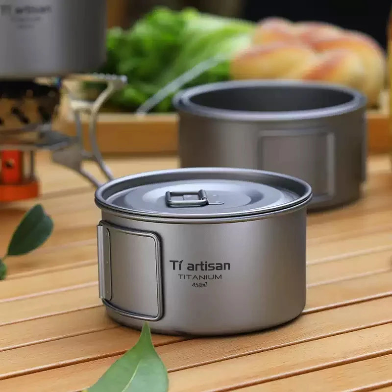 Titanium cookware set with 'Tiartisan' branding on a wooden surface.