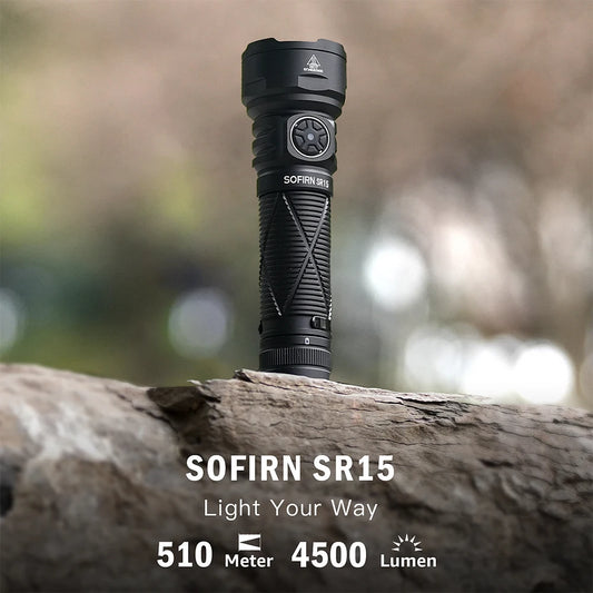 Black flashlight on a log with a blurred natural background