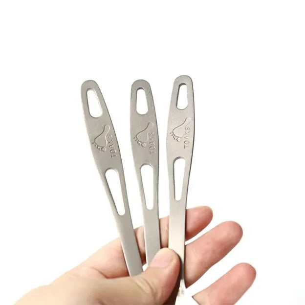 Three metal tools held by a hand with 'TOAKS' branding above.