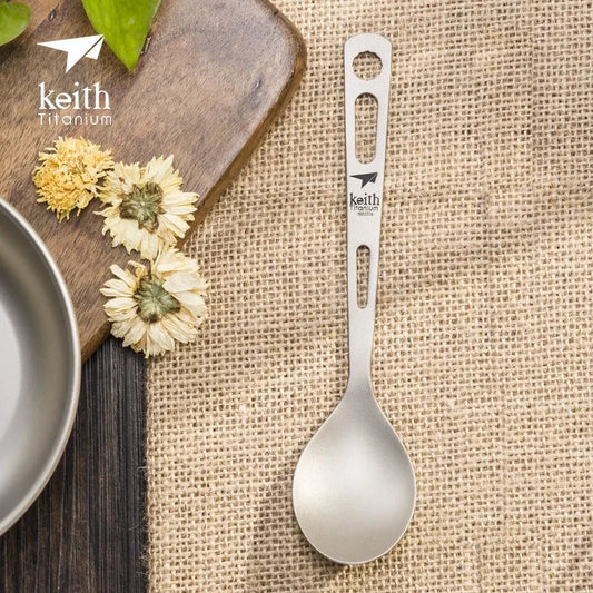 Keith Titanium spoon on a rustic background with flowers and a cutting board.