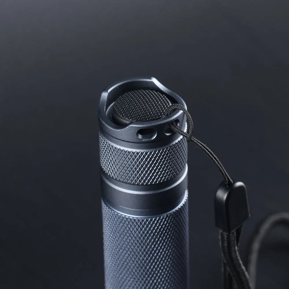 Black flashlight with textured grip and pull switch on a dark background