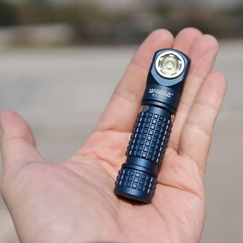 Blue flashlight held in a hand with a blurred background