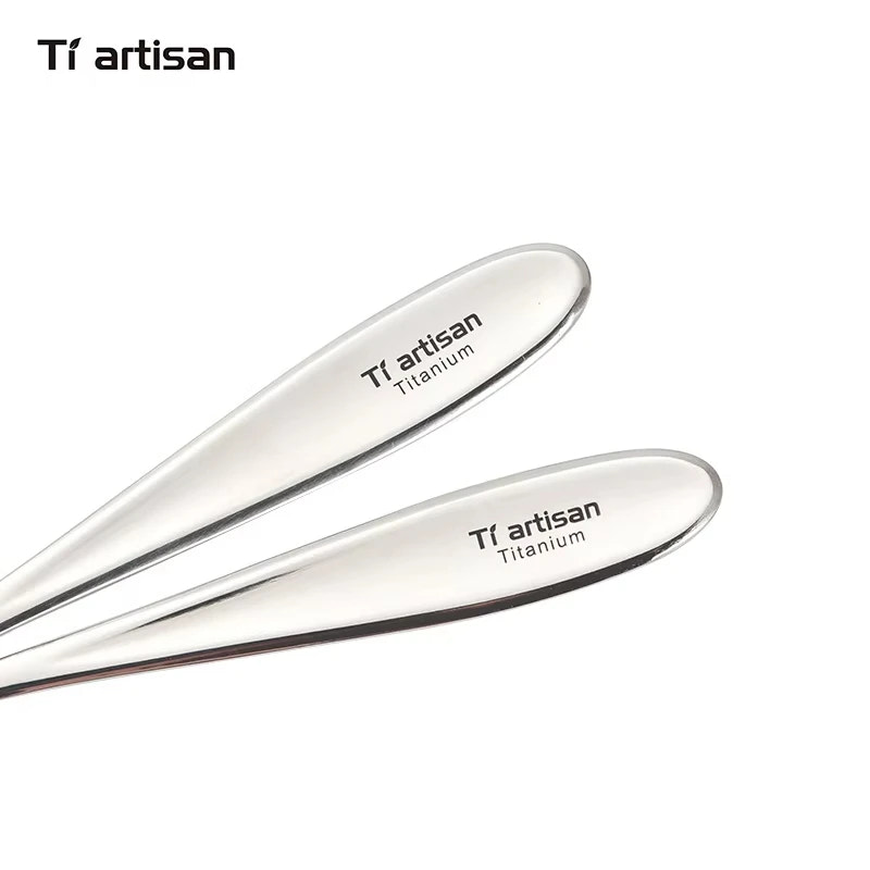 Two titanium utensils with 'Ti artisan' branding on a white background