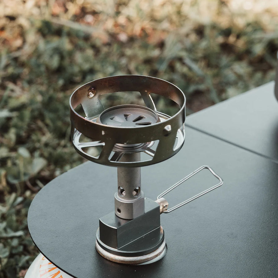 Portable camping stove on a table with a blurred natural background