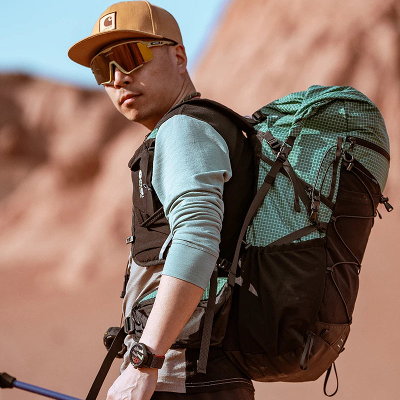 Man with a green backpack and sunglasses in a desert setting