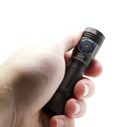 Hand holding a black flashlight with visible branding on a white background