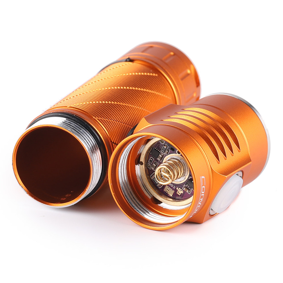 orange flashlight internals with metallic components on a white background