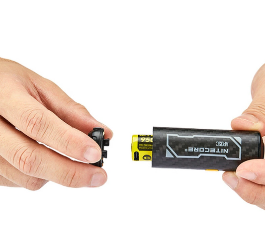 Two hands holding a Nitrocore battery and device on a white background