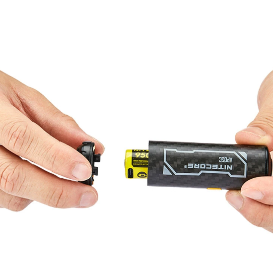 Two hands holding a Nitrocore battery and device on a white background