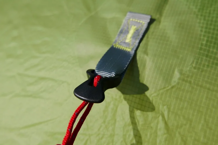Close-up of a strap with a red cord on a green fabric background