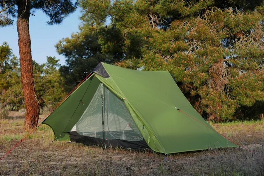 Green camping tent in a forest setting