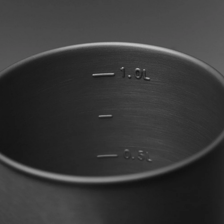 Metal container with measurement markings on a dark background