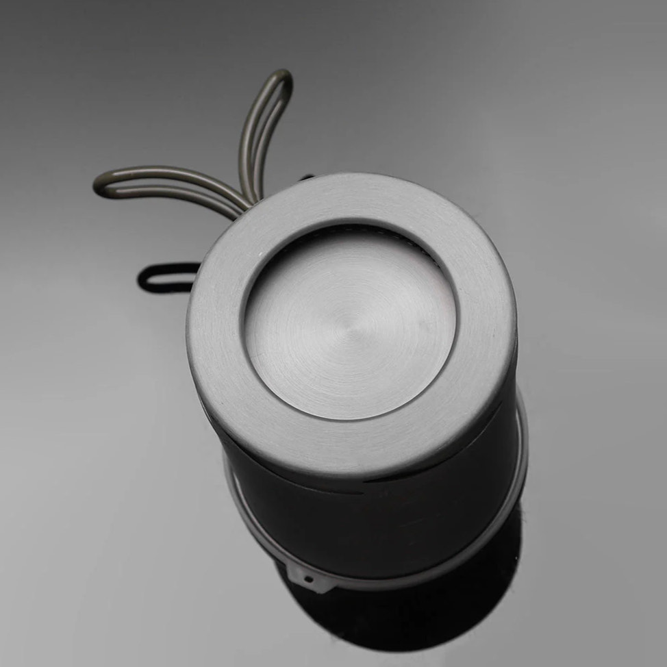 Metallic cylindrical object with a circular top on a gray background