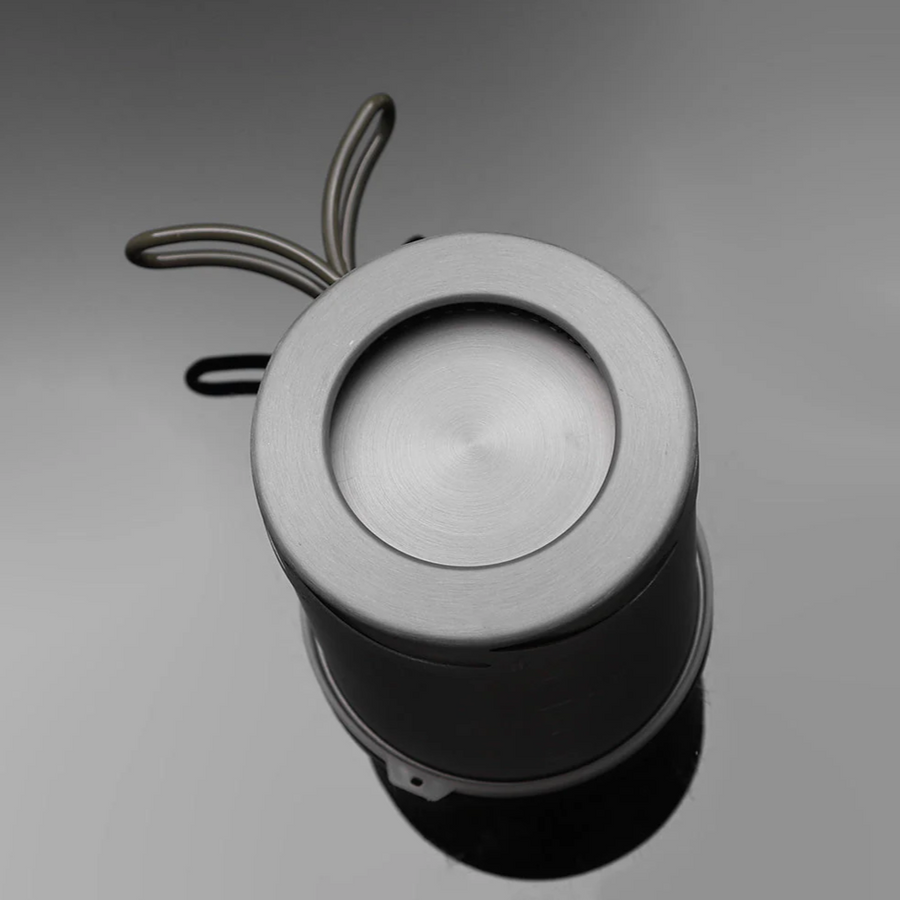 Metallic cylindrical object with a circular top on a gray background