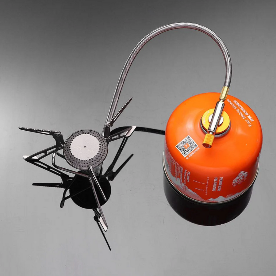 Portable camping stove with orange fuel canister on a gray background