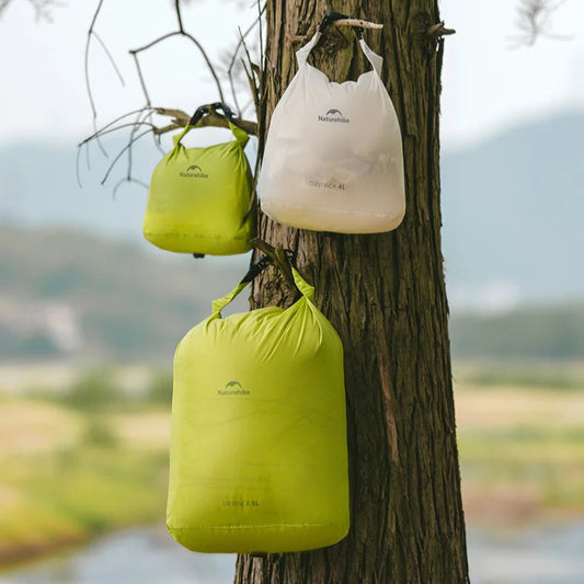 Three green and white bags hanging on a tree with a natural background
