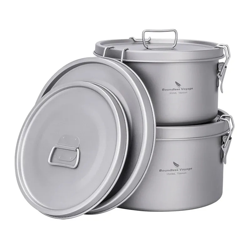 Set of titanium metal pots with lids on a white background