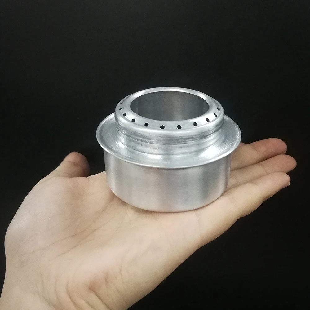 Metallic cylindrical object held in a hand against a black background