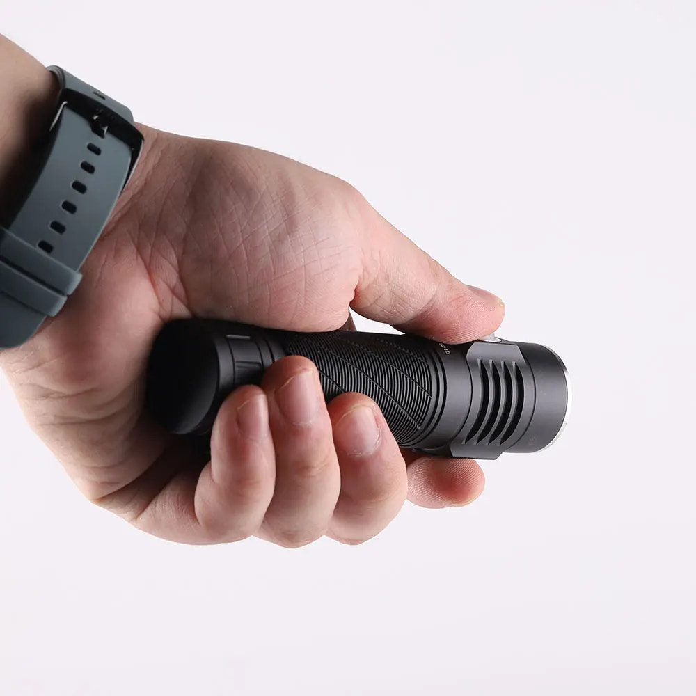 Hand holding a black flashlight against a white background