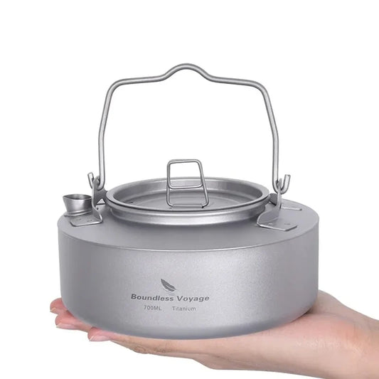 Titanium camping kettle held in a hand with 'Boundless Voyage' branding on a white background