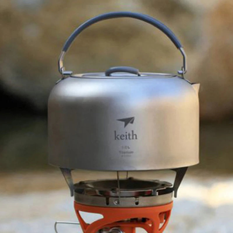 Metallic camping kettle with 'keith' branding on a blurred natural background