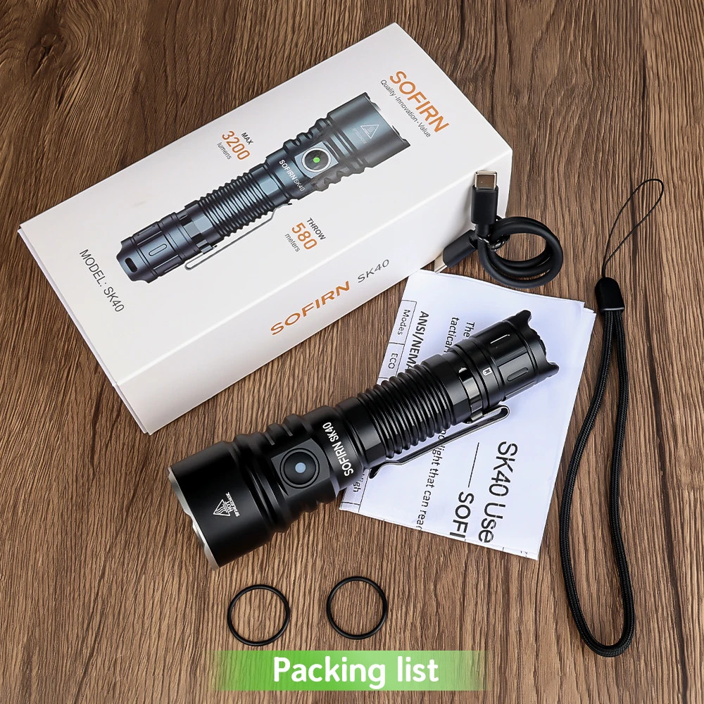 SOFIRN SK40 flashlight with packaging, USB cable, and accessories on a wooden surface
