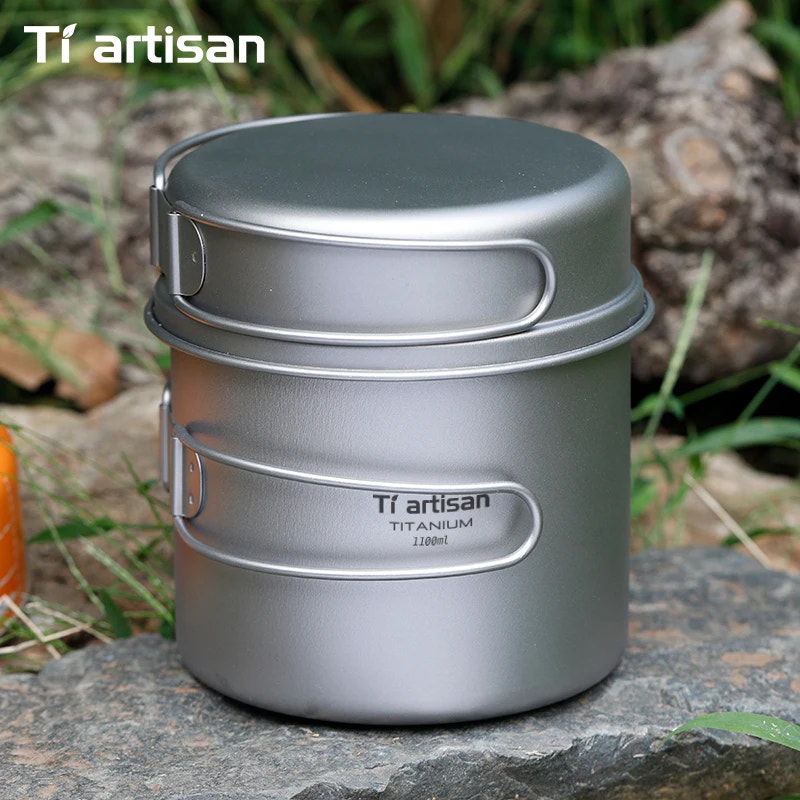 Titanium cooking pot with lid on a stone surface, featuring Tiartisan branding.
