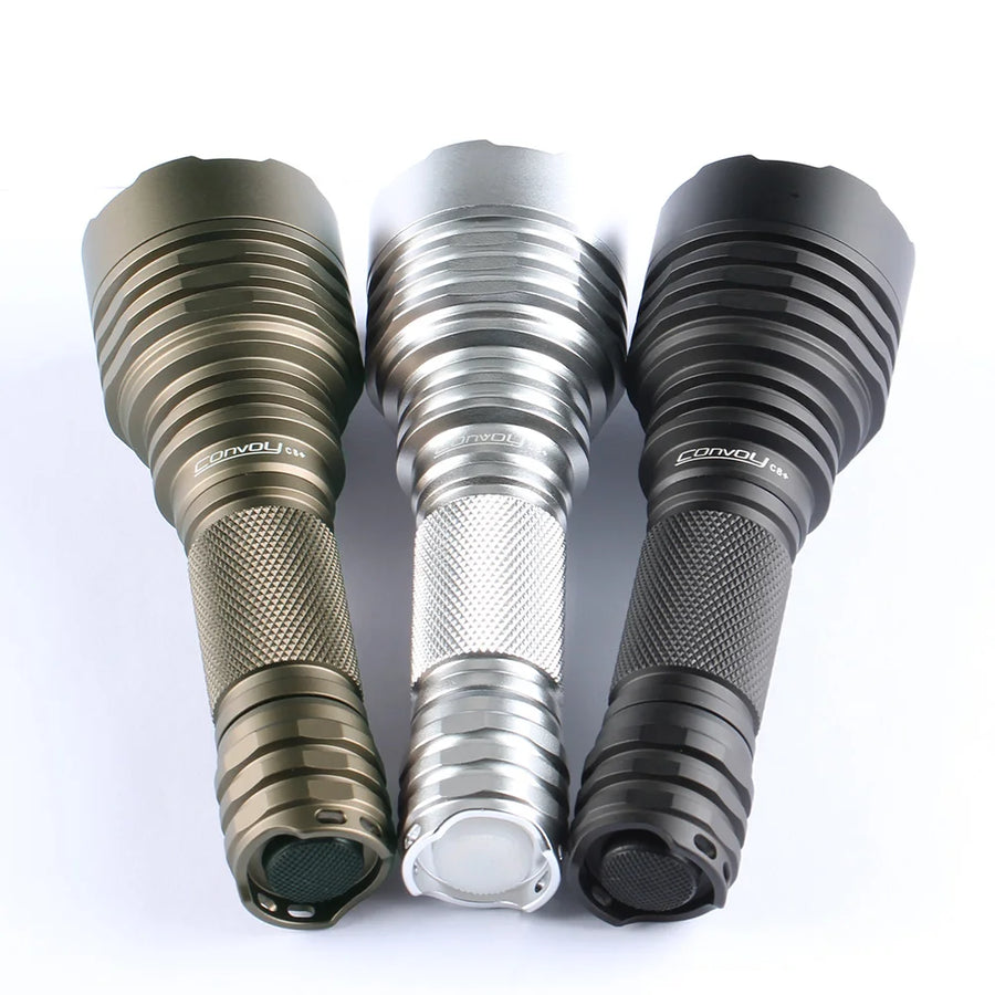 Three flashlights in gold, silver, and black on a white background