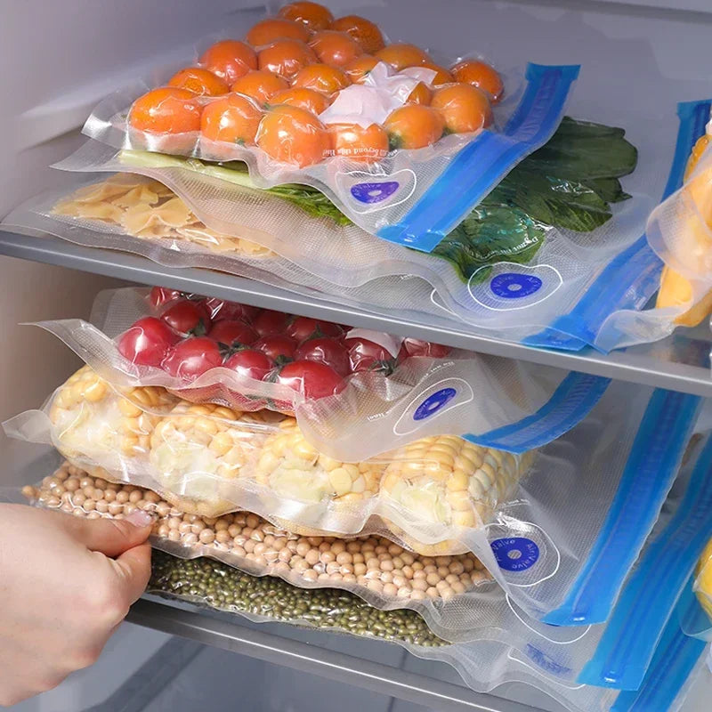 Vacuum-sealed food bags with vegetables and grains inside a refrigerator.