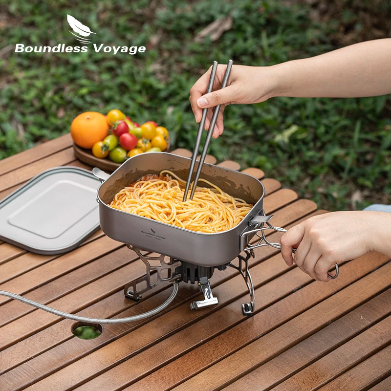 Person cooking spaghetti on a portable stove with 'Boundless Voyage' branding.
