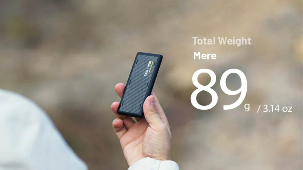 Hand holding a power bank with weight information displayed